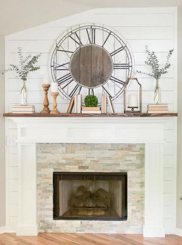 a rustic clock with roman numbers hung above the mantel